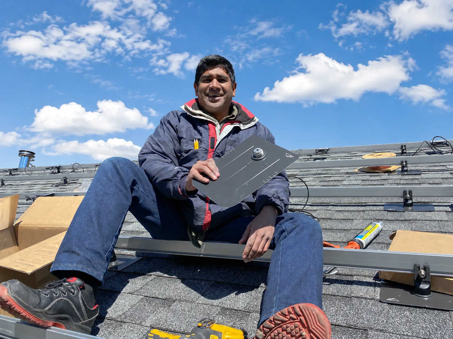 Navneet Jain and team installing solar panels on a rooftop at sunset